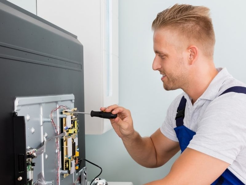 Fotografía de técnico reparando Televisores Indesit